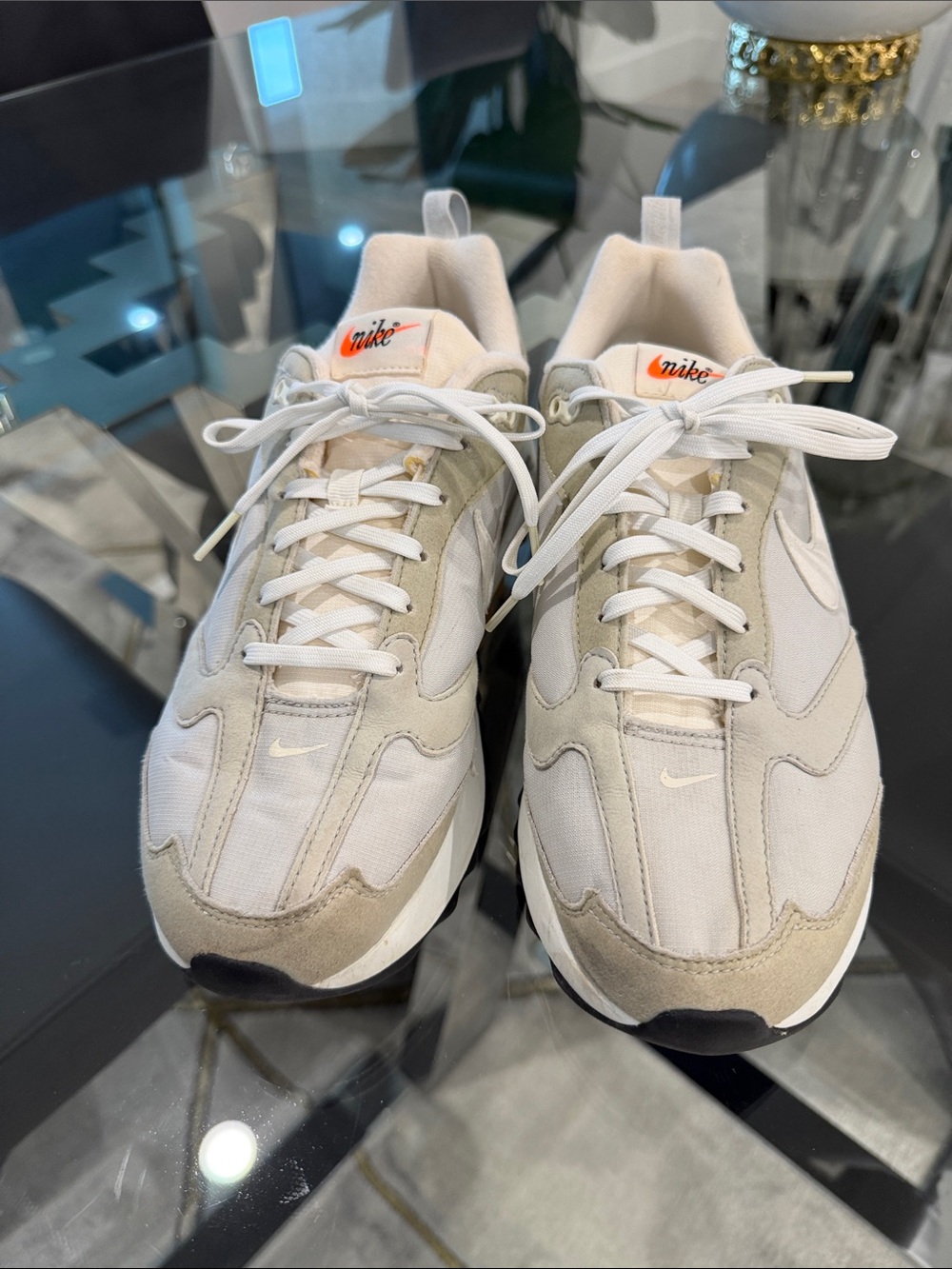 Nike Air Max Dawn sneakers in a grey and white colorway with an orange logo.